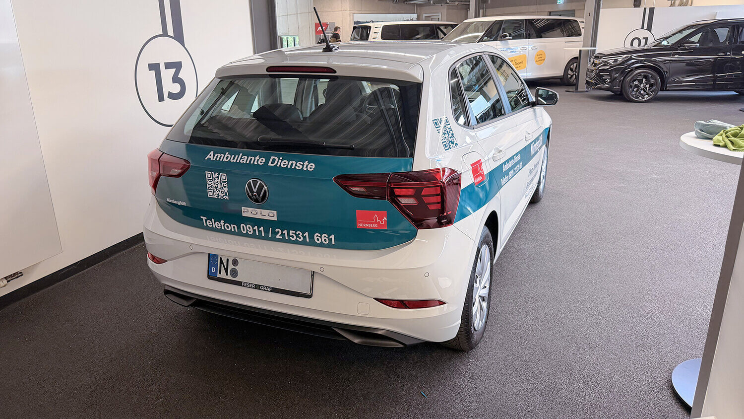 Heck eines beklebten VW Polo mit Aufschrift Ambulante Dienste und Telefonnummer