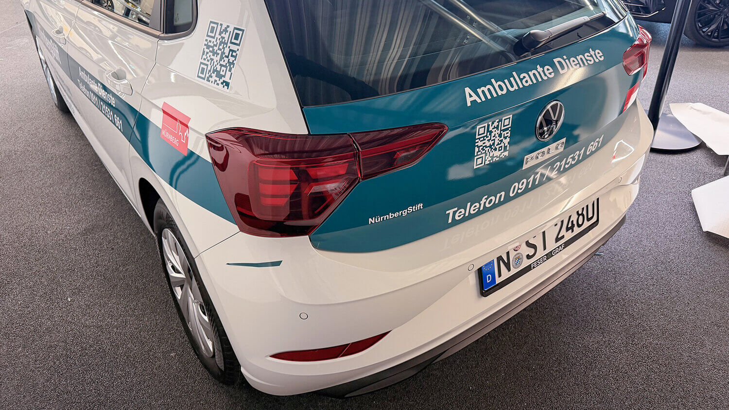 Seitenansicht eines VW Polo mit NürnbergStift-Fahrzeugbeklebung